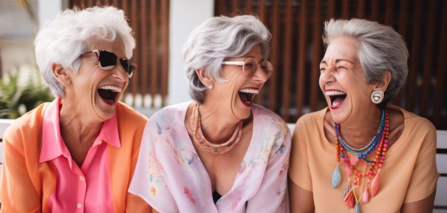 Drei ältere Frauen, die herzhaft lachen